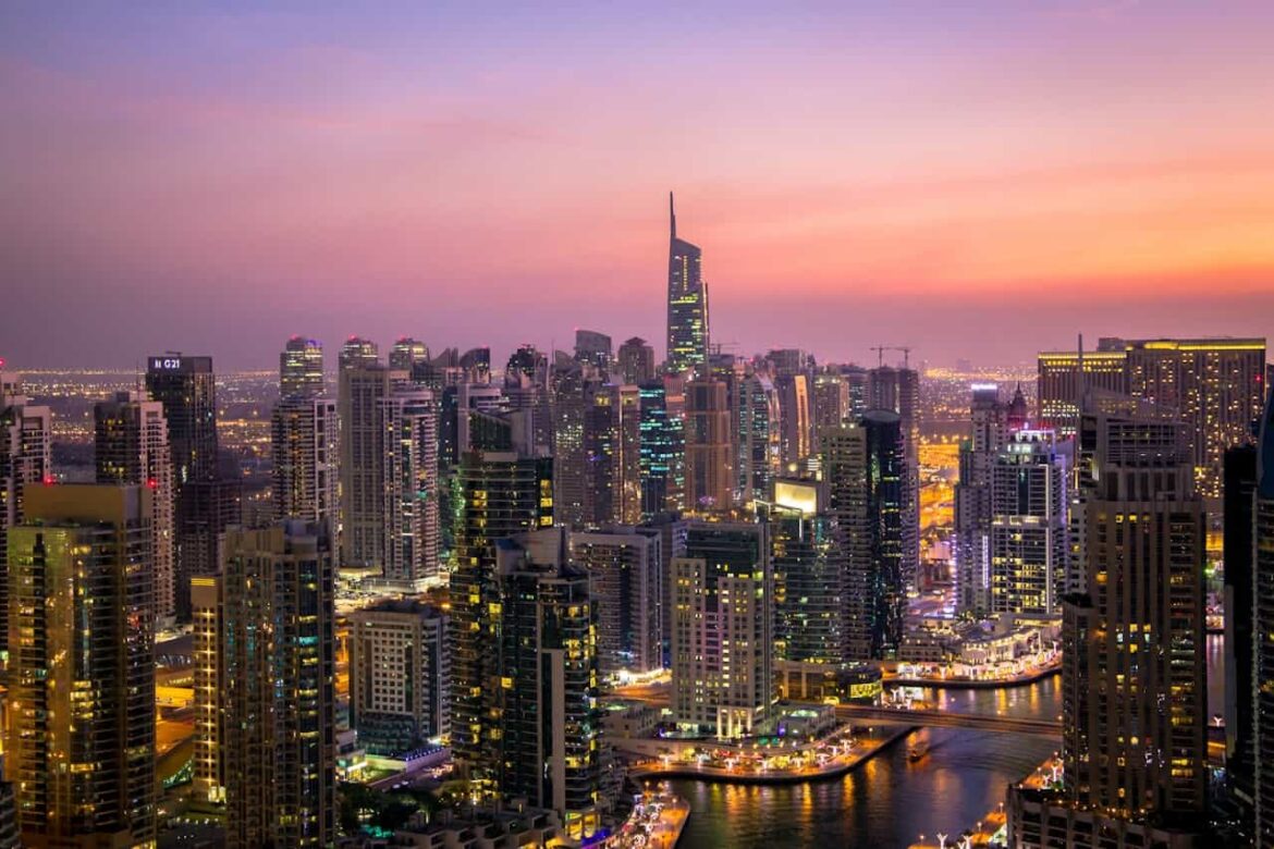 Vue panoramique de la skyline illuminée au coucher du soleil pour savoir que faire à Dubaï le soir