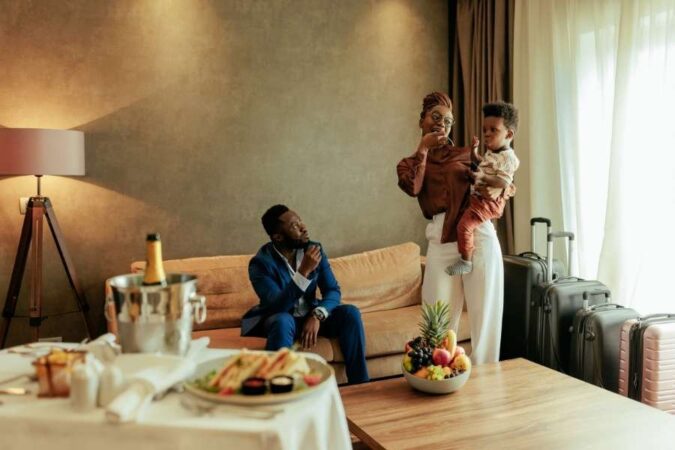 Une famille avec un jeune enfant arrive dans une chambre spacieuse d'un hôtel familial.